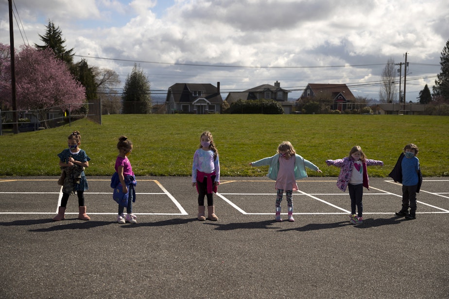 caption: Jackson Elementary kindergarteners distance themselves while lining up to return from recess on Tuesday, March 23, 2021, at the school along Federal Avenue in Everett. With hybrid learning, students have the option to attend in-person classes two days per week.