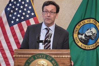 caption: Washington Gov. Bob Ferguson answers questions at a news conference Tues. April 1, 2025.