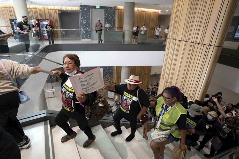 caption: Supporters of a bill to give domestic workers the same safety protections required by law for other employees, march through the Capitol Annex Swing Space office building in Sacramento, Calif., Tuesday, Aug. 29, 2023.