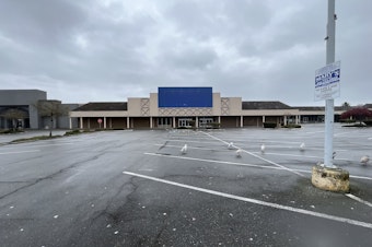 caption: Many parking lots like this one in Lynnwood near the light rail station are being replaced by housing developments.