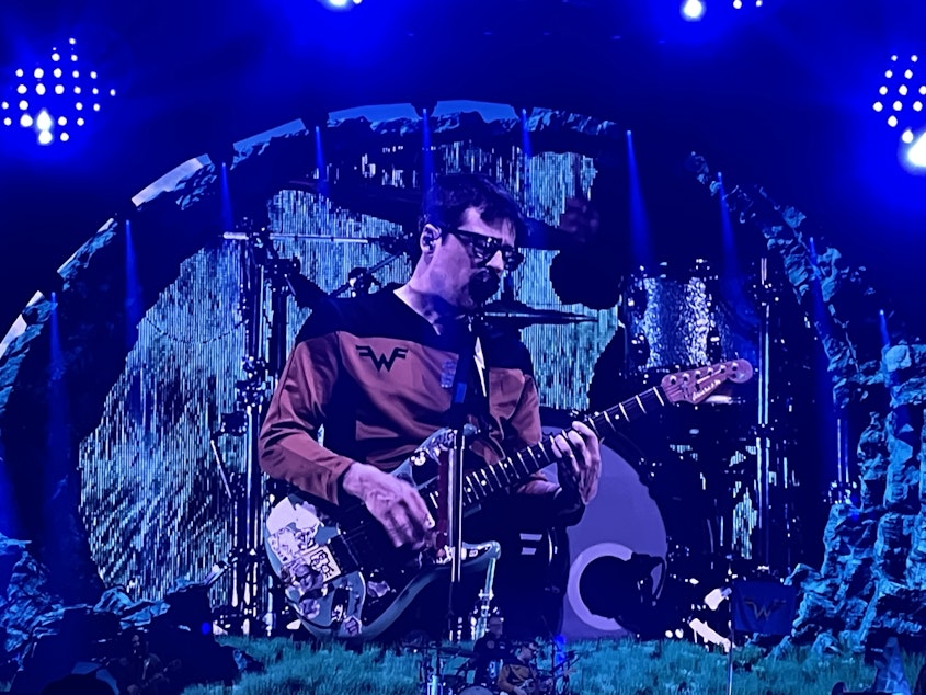 caption: Rivers Cuomo performs with Weezer on Oct. 4, 2024 at Seattle's Climate Pledge Arena as part of the Voyage to the Blue Planet tour.