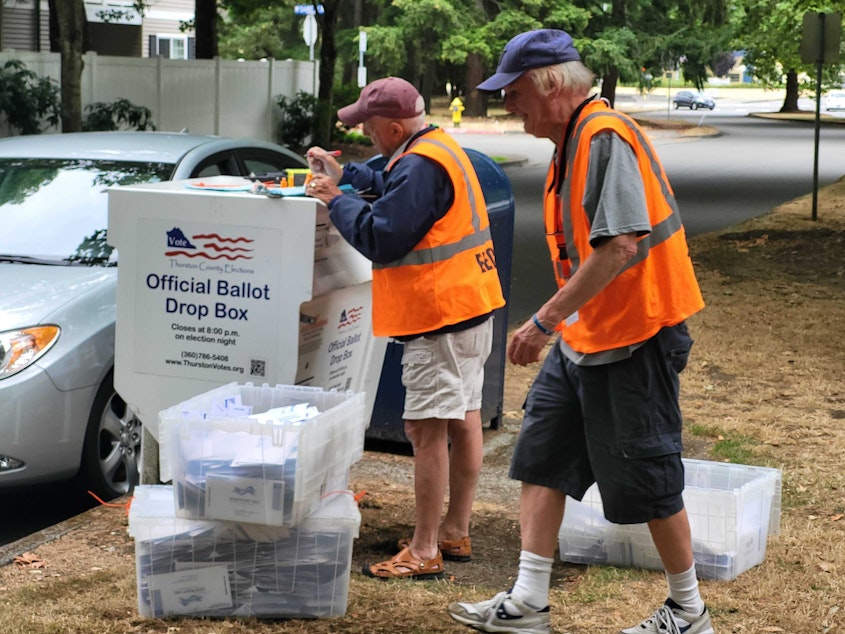 caption: As voters visited the busiest drop box in Thurston County, located at the Lacey Post Office, two election workers arrived to pick up ballots and take them to the county's ballot processing center for the state’s primary election, Aug. 6, 2024.