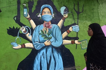 caption: A street painting in Mumbai, India, reinforces the importance of masks amid a surge of COVID. The photo was taken on January 11.