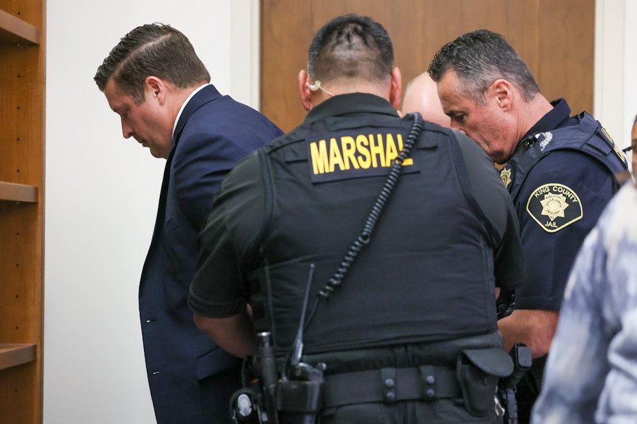 caption: Auburn police Officer Jeffrey Nelson is taken into custody after a jury in Kent convicted him Thursday of second-degree murder and first-degree assault in the 2019 shooting death of Jesse Sarey.