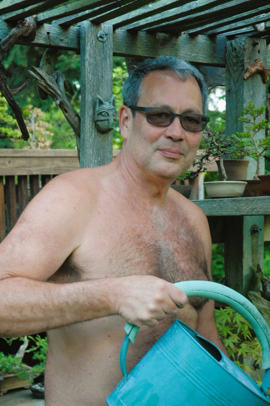 caption: Mark Storey, co-creator of World Naked Gardening Day, doing what he loves in his favorite suit.