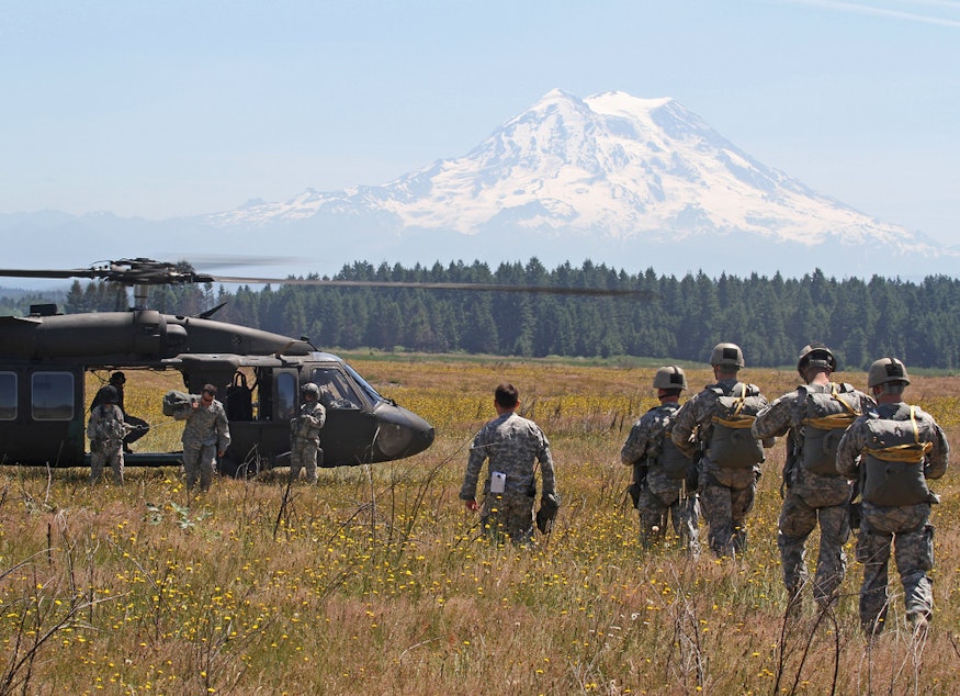 caption: Soldiers prepare for static-line skydiving from a Blackhawk helicopter in a prairie at Joint Base Lewis McChord on June 17, 2015.