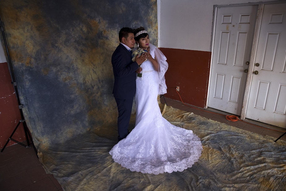caption: Argimiro Nuñez and Honorina Hernandez pose for a portrait for their wedding photographer before a mass wedding ceremony where they were married along with 22 other couples on Sunday, June 2, 2019, at Our Lady of the Desert Church in Mattawa.