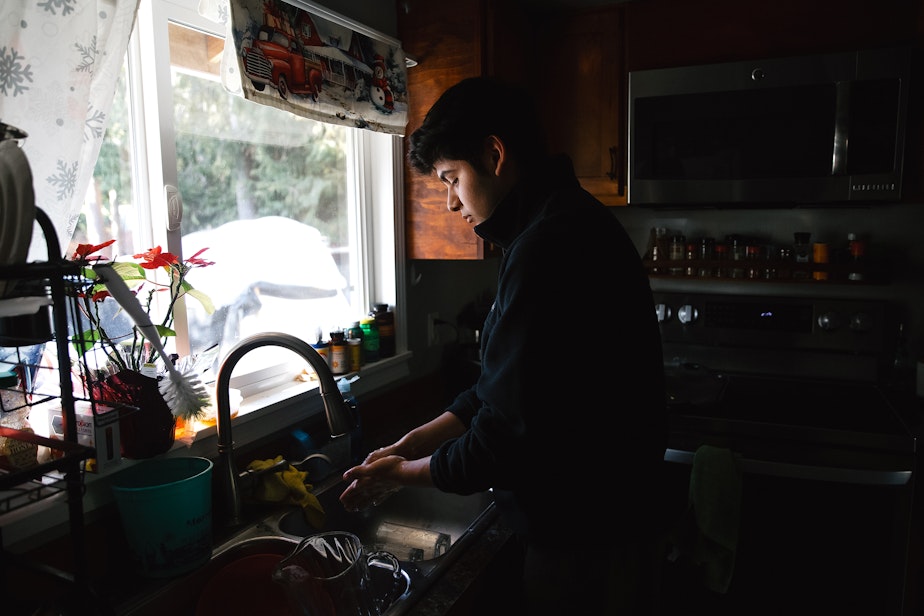 caption: Alex Villatoro, 17, washes his hands after feeding his families chickens and ducks on Wednesday, March 5, 2025, at his home in Maple Falls, Washington.
