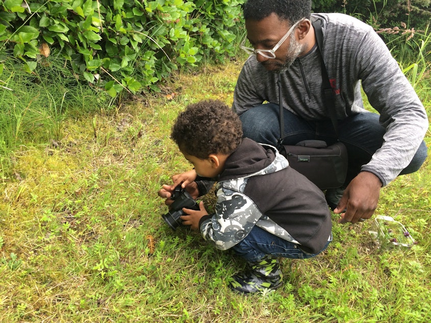 caption: Damon Taylor, a member of the West Coast Birders Facebook group, shows his son a slug at Westport Light State Park