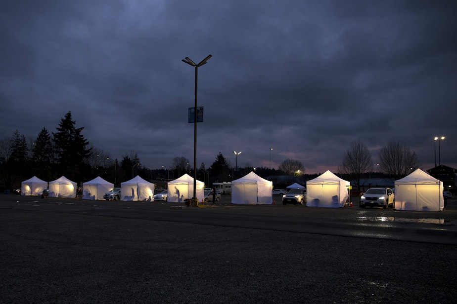 caption: A line of vaccine tents are lit up as the sun goes down on Thursday, January 28, 2021, during a free drive-thru Covid-19 vaccination clinic at the Washington State Fair Events Center in Puyallup. The clinic vaccinated approximately 2,000 people in phases 1A and 1B of the state’s vaccination plan on Thursday.
