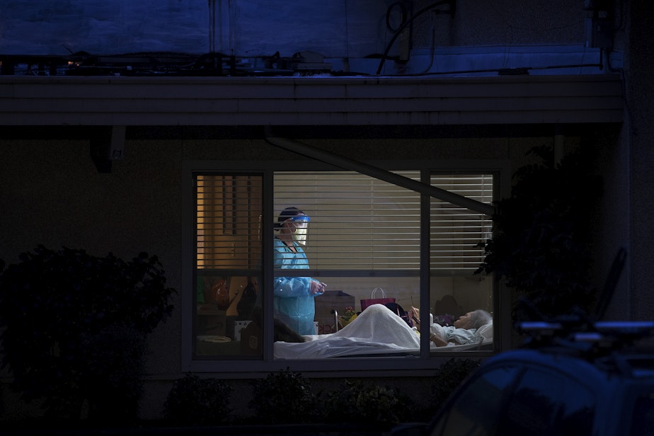 caption: A health worker talks with Susan Hailey, 76, in her room at the Life Care Center of Kirkland, on Friday, March 13, 2020, in Kirkland.