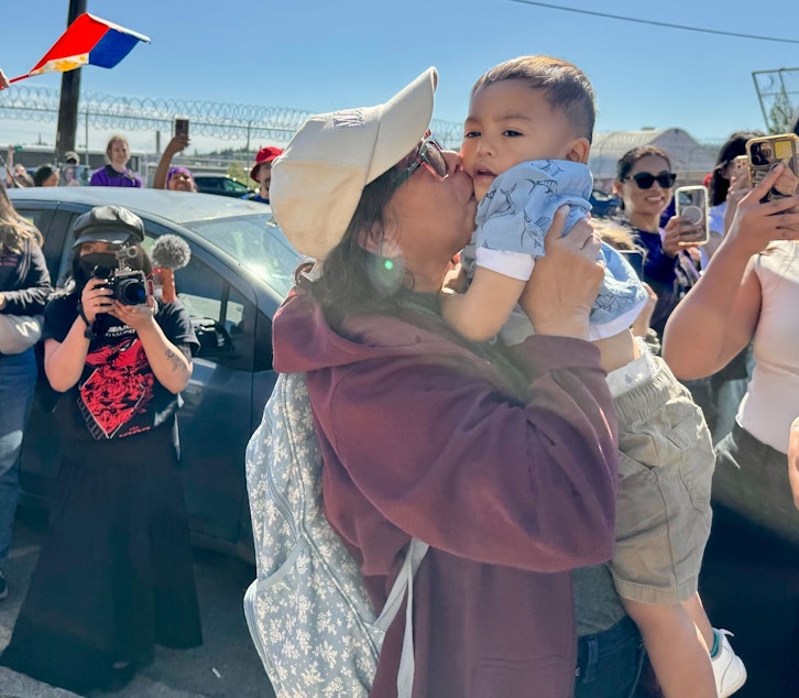 caption: University of Washington employee and Filipina green card holder Lewelyn Dixon kisses her great-grandnephew on the cheek following her release from the Tacoma ICE center on Thursday, May 29, 2025.