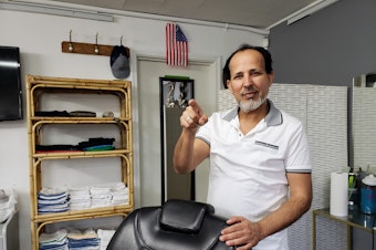 caption: Ibrahim Aljalal in his Kent barbershop, Golden Scissors on Monday, April 28, 2025.