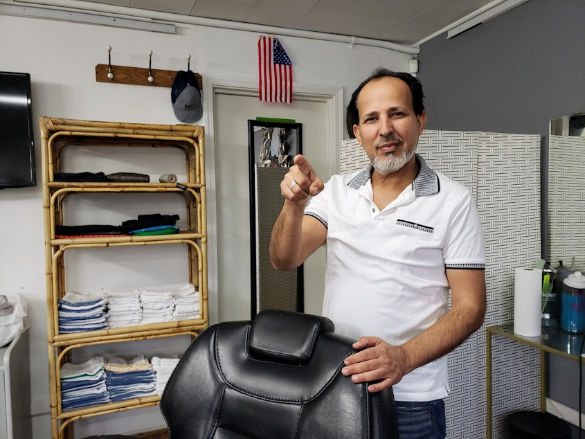 caption: Ibrahim Aljalal in his Kent barbershop, Golden Scissors on Monday, April 28, 2025.