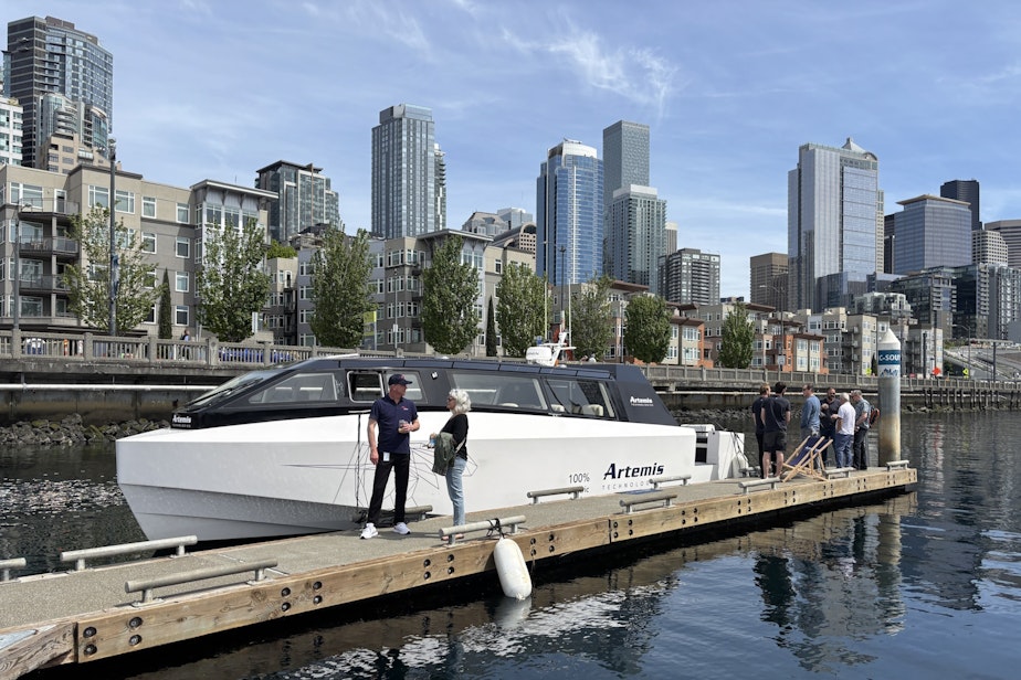 caption: A smaller Artemis boat docked in Seattle, with FRS Clipper staff chatting in front.