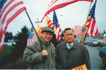 caption: Thanh's father, Duc Tan, holds the American flag and stands next to Dr. Dung Nguyen, president of the Vietnamese Community of Pierce County, at a political rally in this undated photo. 