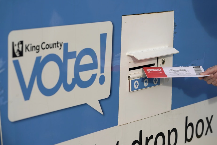 caption: A person puts their ballot in a drop box on Oct. 27, 2020, at a library in Seattle.