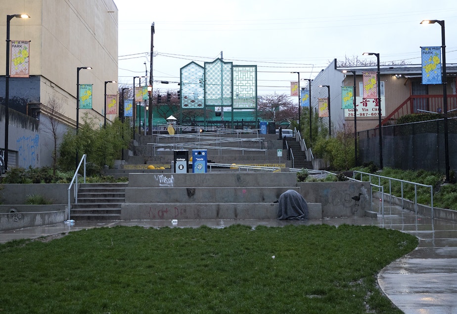 caption: A person is shown under a blanket at Hoa Mai Park on Thursday, March 20, 2025, in Seattle’s Little Saigon neighborhood. 