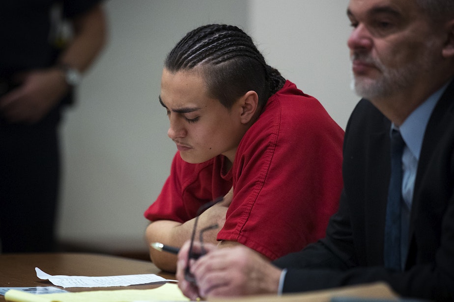 caption: Julian Tuimauga, left, listens as the video that that he took immediately after the beating plays for the judge, with his defense attorney Robert Huff on Friday, November 16, 2018, during his sentencing at the Maleng Regional Justice Center in Kent.