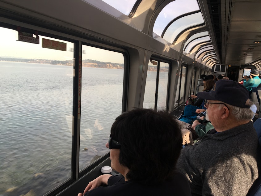 caption: Passengers on Amtrak's Coast Starlight watch Puget Sound roll by