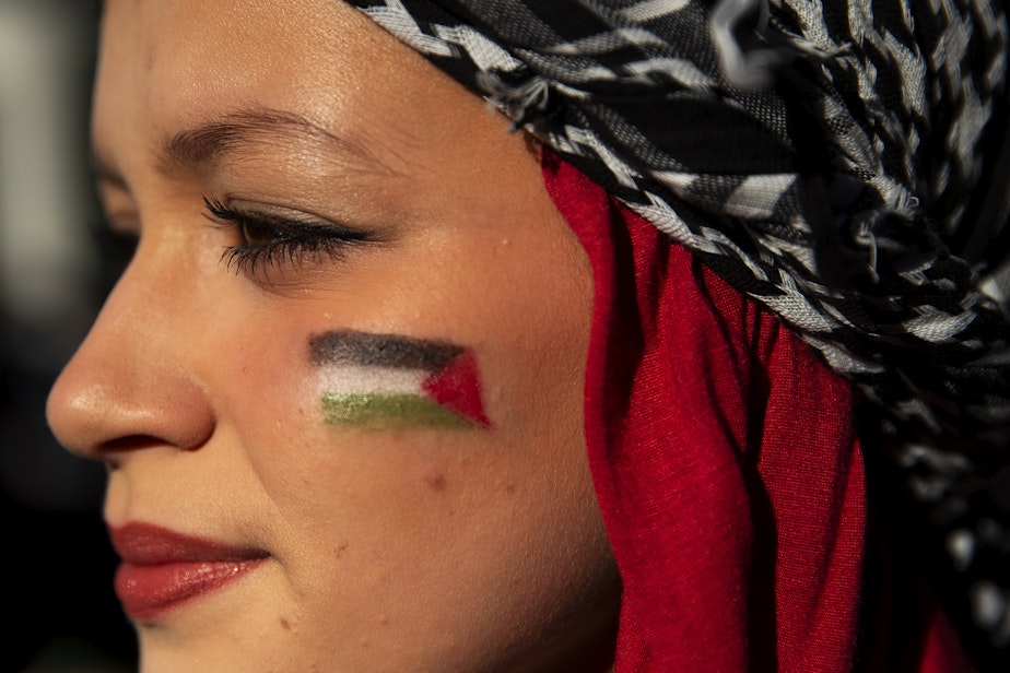 caption: Aliyah Sadoune, 15, of Kent, listens to speakers as thousands gathered at Westlake Park to show support for Palestine on Saturday, October 28, 2023, in Seattle.
