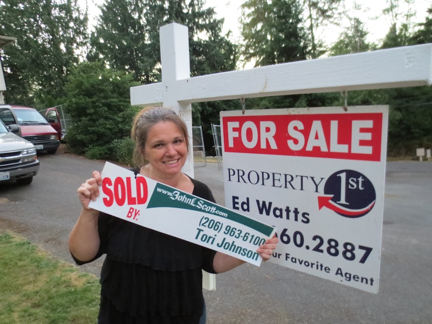 caption: Natalie Johnson in front of her new home.