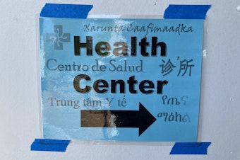 caption: A sign directs students at the Seattle World School to the building's health clinic
