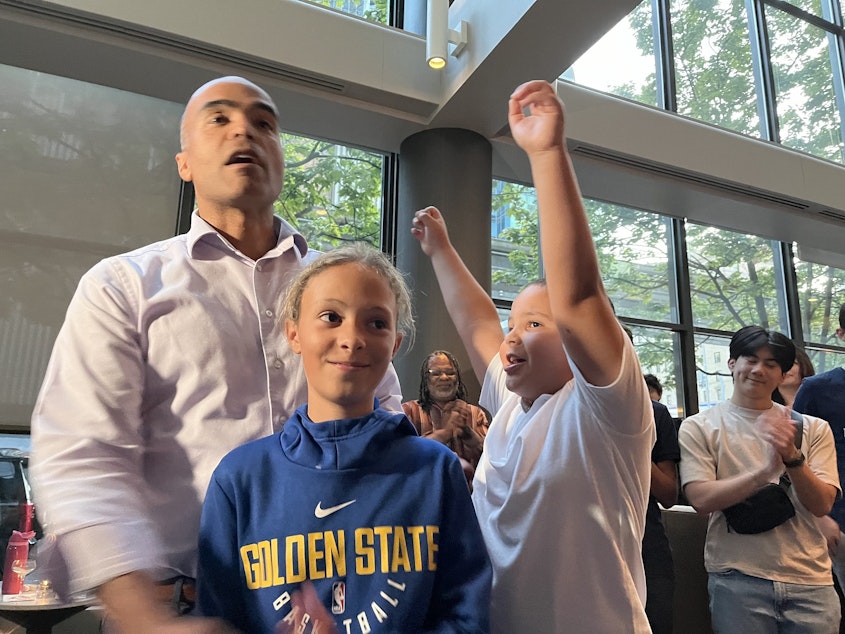 caption: Nick Brown and his children celebrate his initial showing in the race for Washington Attorney General in the primary Tuesday, Aug. 6, 2024.