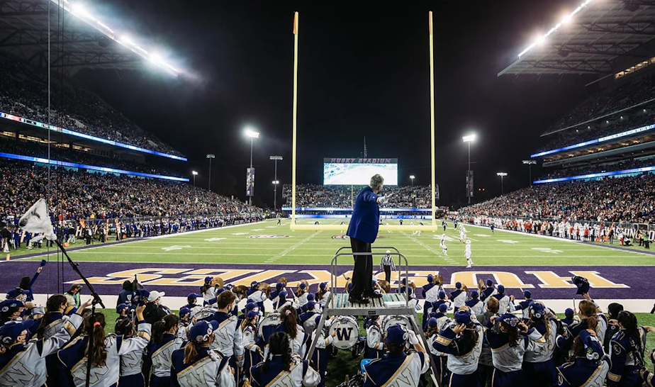 caption: Dr. Brad McDavid, director of the Husky Marching Band, during a performance at Husky Stadium.